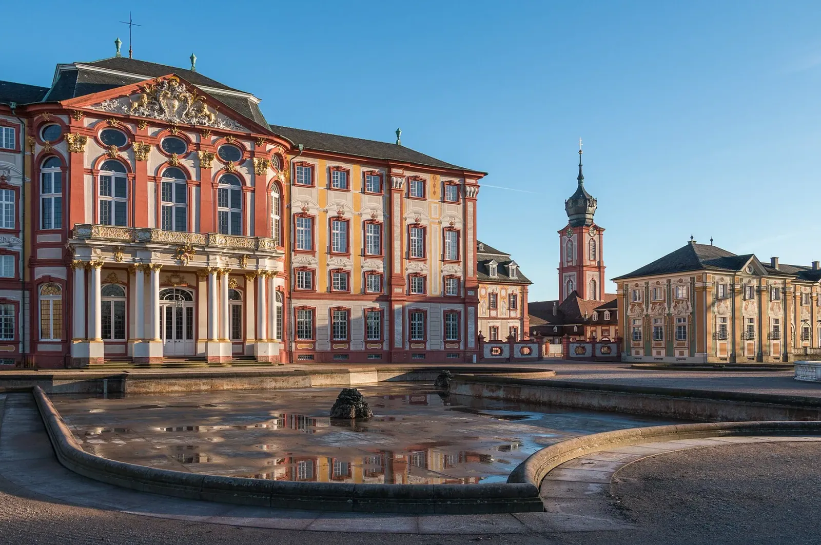 Das Barockschloss Bruchsal mit Ehrenhof und Stadtkirchturm im Abendlicht