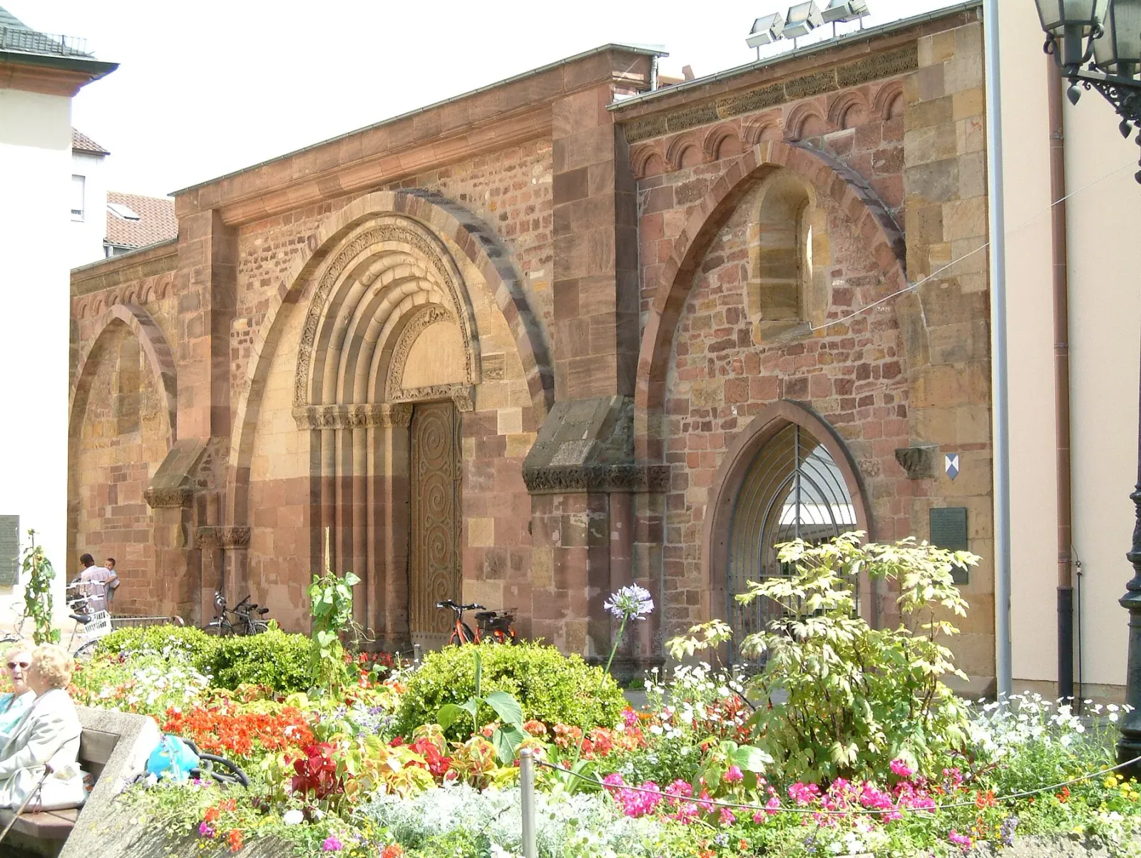 Erkenbert-Ruine in Frankenthal (Pfalz) im Sommer, davor ein blühendes Blumenbeet