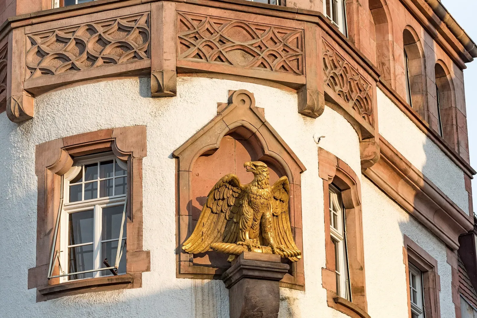 Erkerfassade am Rathausplatz in Landau in der Pfalz mit vergoldeter Adlerfigur in einer Sandsteinnische, im Sommerlicht